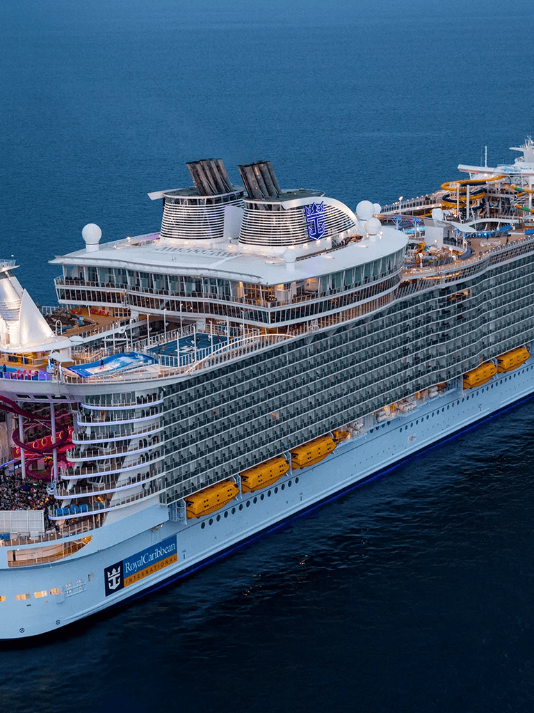 Luxury cruise ship docked at sea, Royal Caribbean International vessel, vacation, luxury travel, ocean cruise.