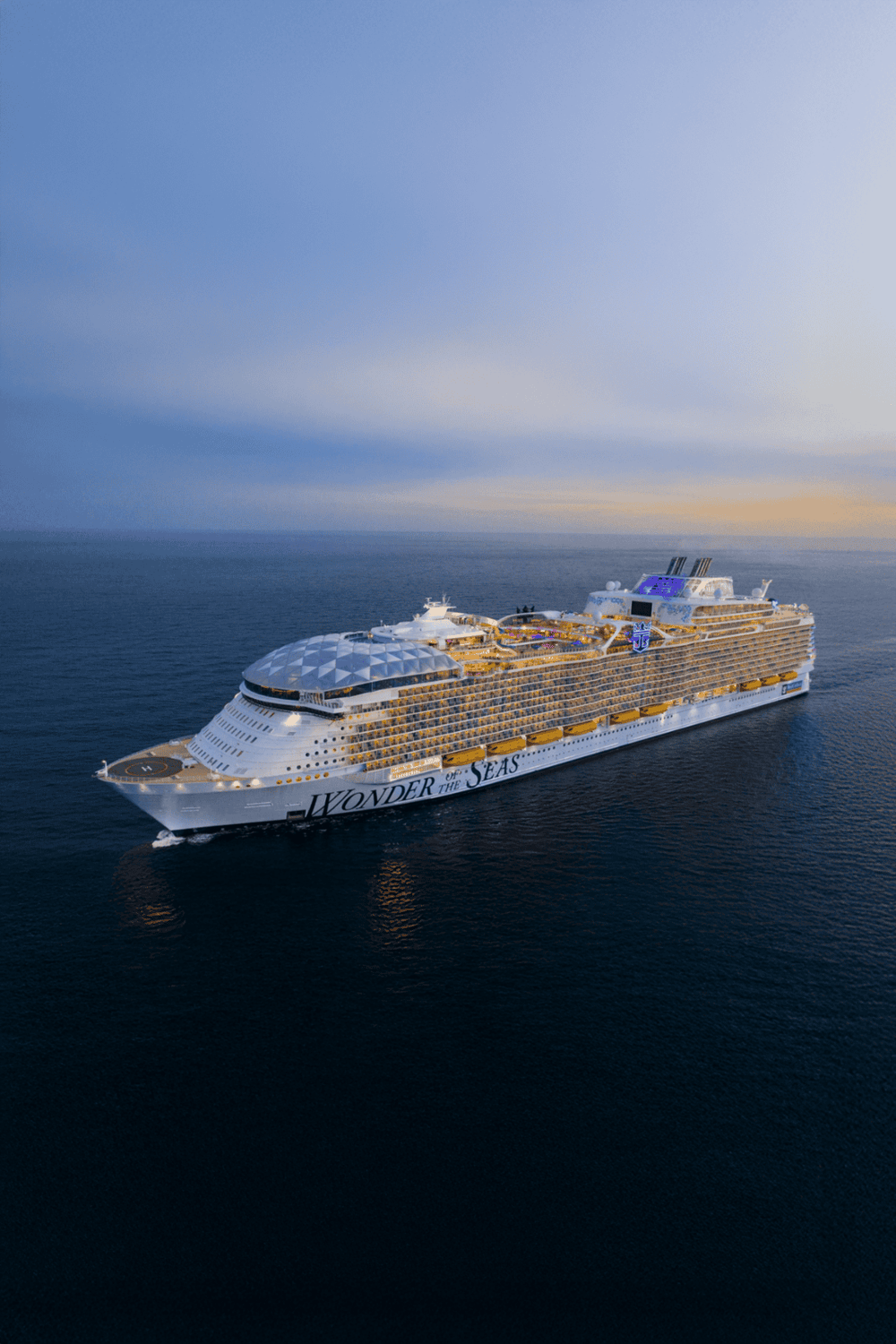 Luxury cruise ship "Wonder of the Seas" sailing at sunset.