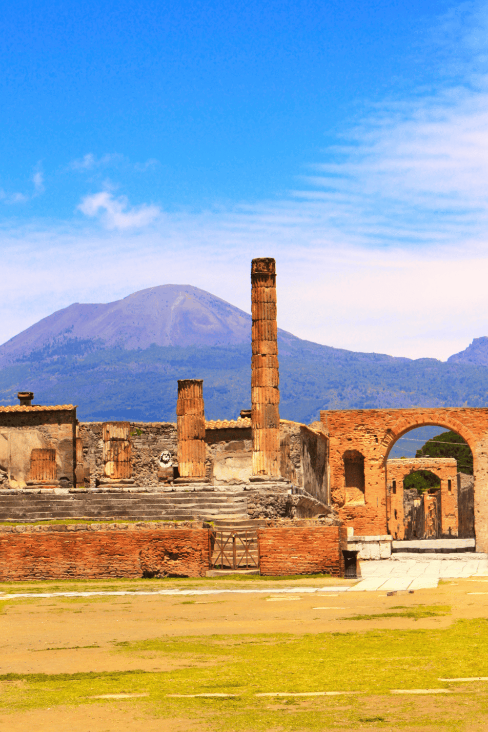 Ancient Roman ruins with Mount Vesuvius in the background, showcasing Italy's historical landmarks.