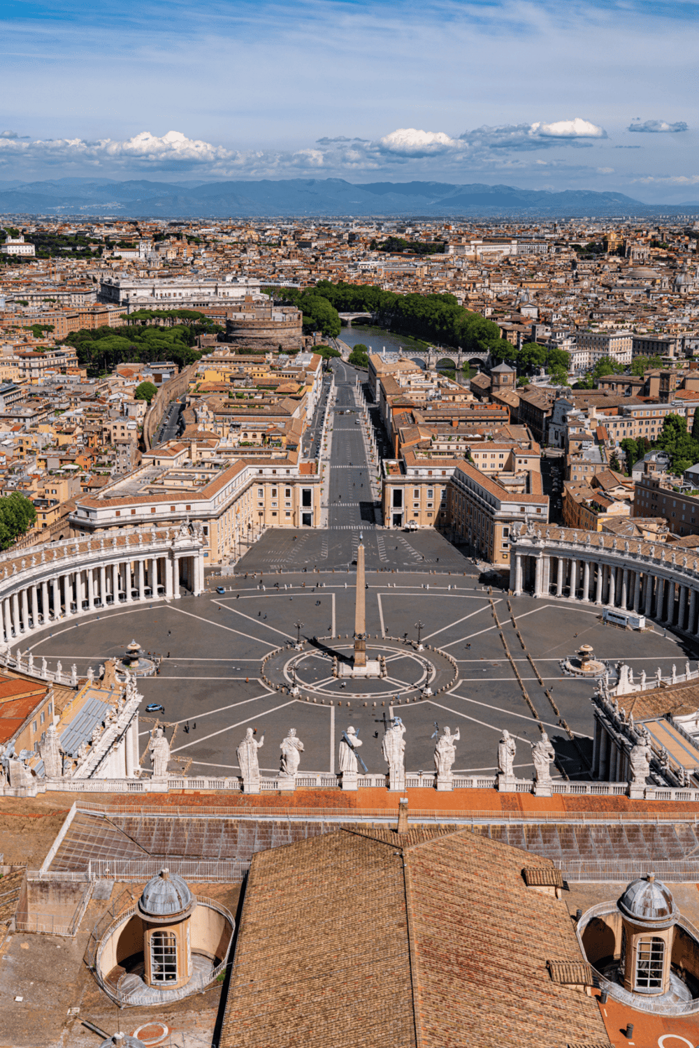 St. Peter’s Square, Vatican City, Rome with the cityscape and mountains in the background.