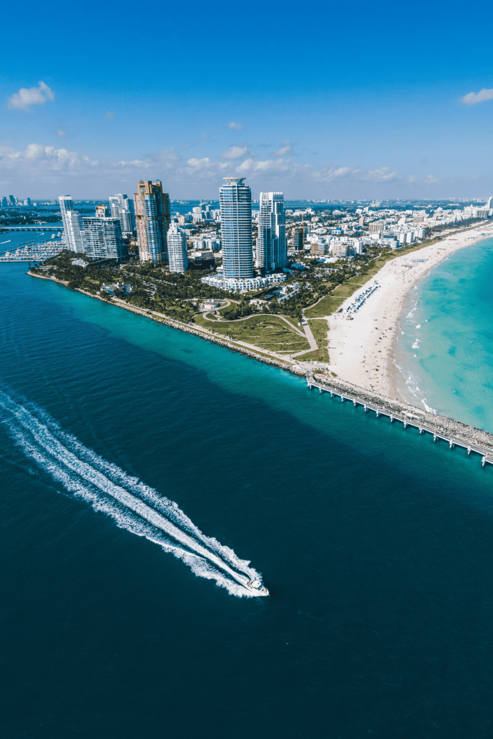 Luxurious Miami Beach skyline with ocean view and boat cruising.