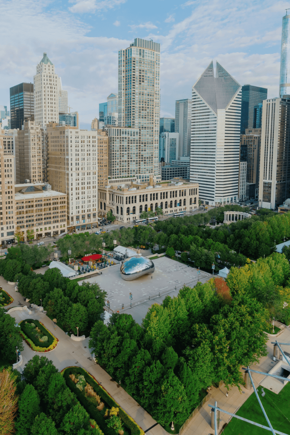 Modern city skyline with lush green park, iconic Cloud Gate sculpture, tall skyscrapers in Chicago downtown.