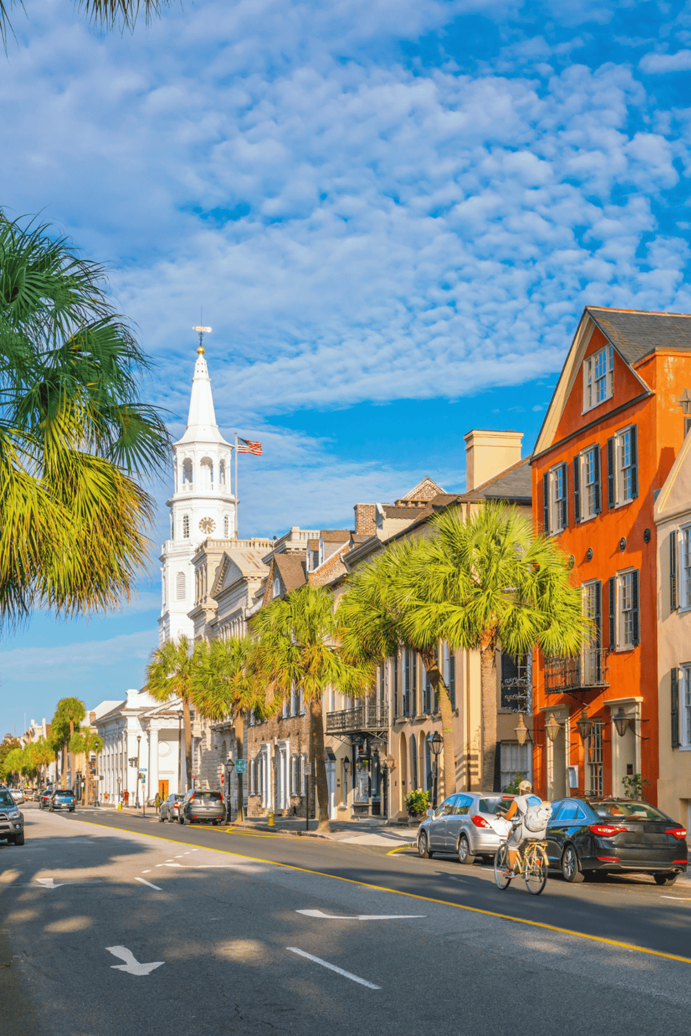 Colorful historic street in Charleston, South Carolina with palm trees and colonial architecture.