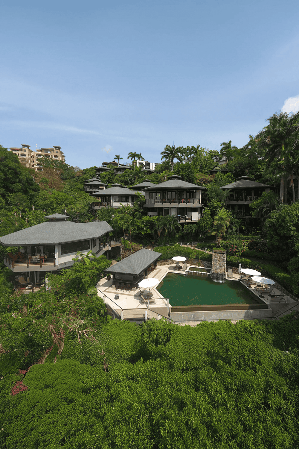 Luxurious hillside vacation villas with private pools and lush greenery, perfect for a relaxing getaway.