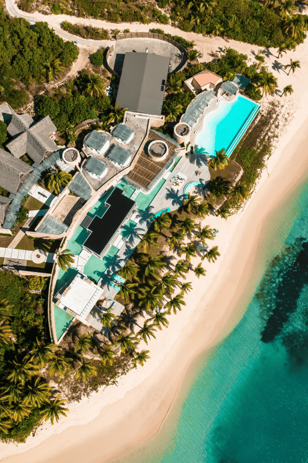 Luxurious beachfront resort with infinity pool, lush greenery, and ocean views for perfect travel destinations.