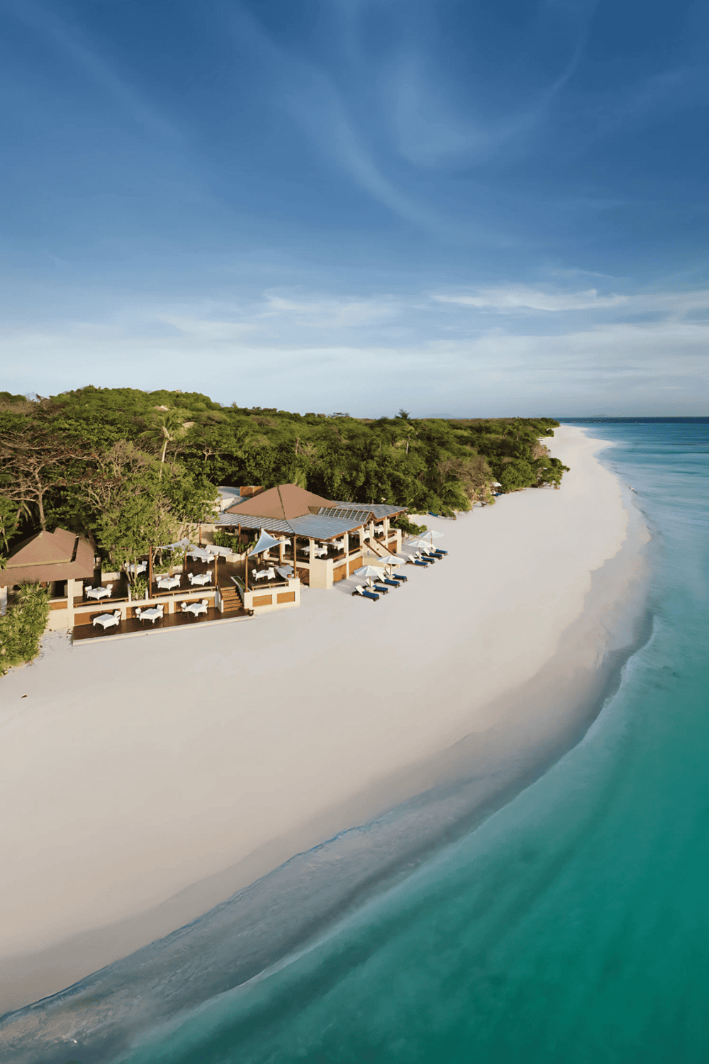 Luxurious beachfront resort with turquoise waters and white sandy beach, perfect for relaxation and vacations.