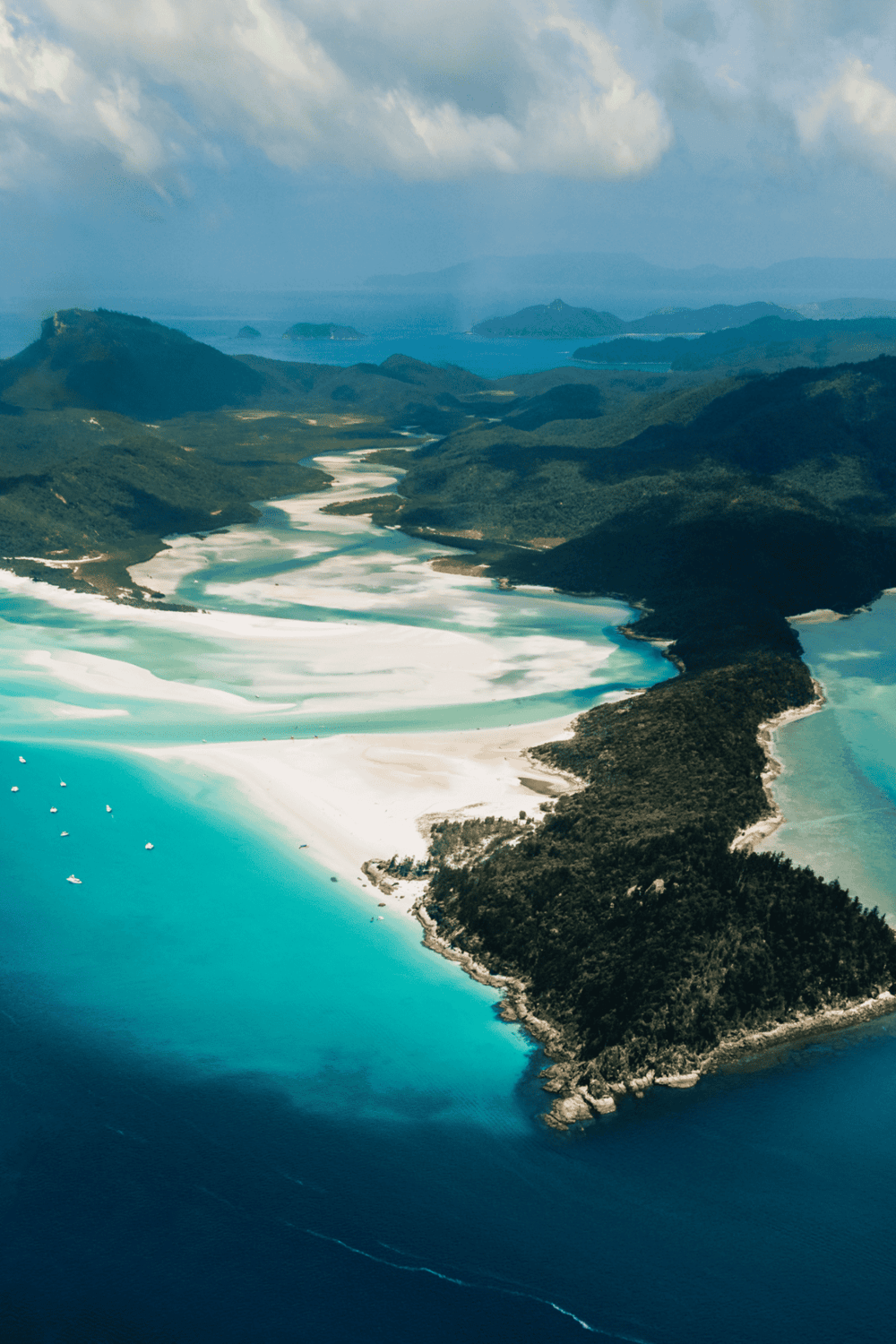 Vibrant aerial view of coastal landscape with winding turquoise river, lush green hills, and sandy beaches perfect for adventure travel.