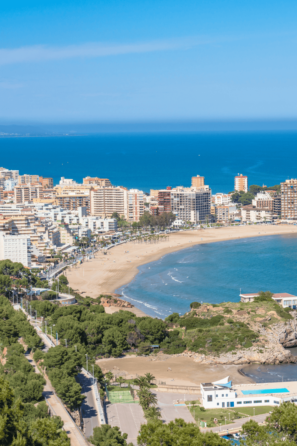 Aerial view of Costa Blanca beach with city skyline and blue ocean.