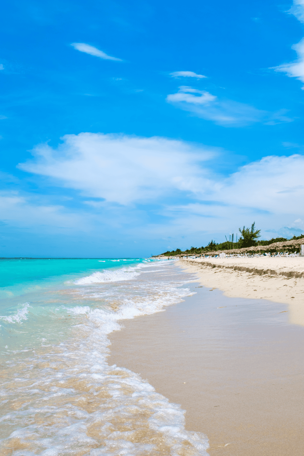 Bright tropical beach with turquoise water and white sandy shore, perfect for vacation.