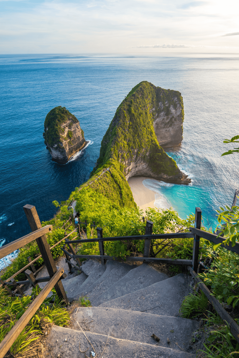 Bali's stunning Kelingking Beach viewpoint with steep stairs and lush greenery.