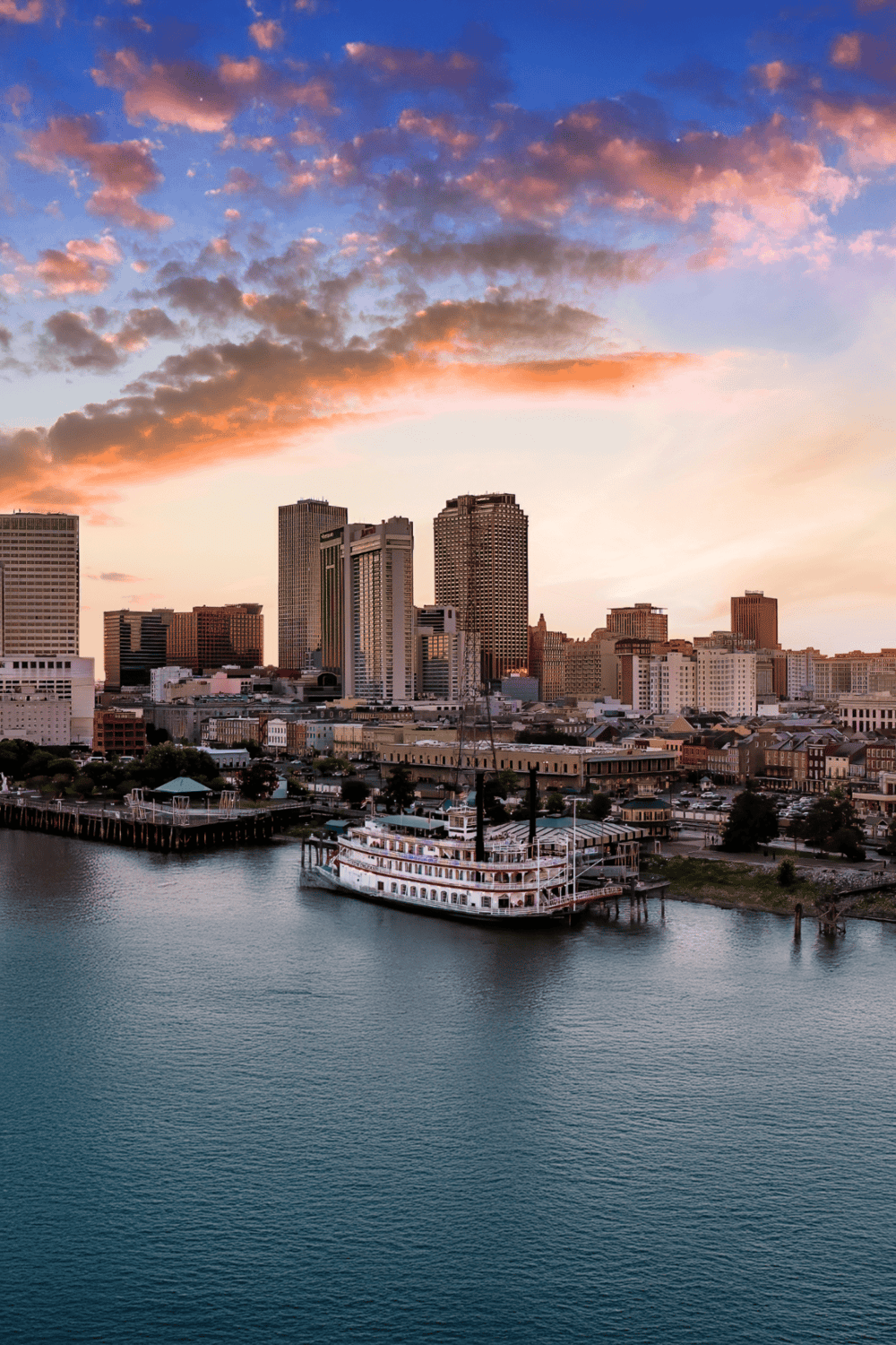 Beautiful Tulsa skyline at sunset with river view and historic boat dock.