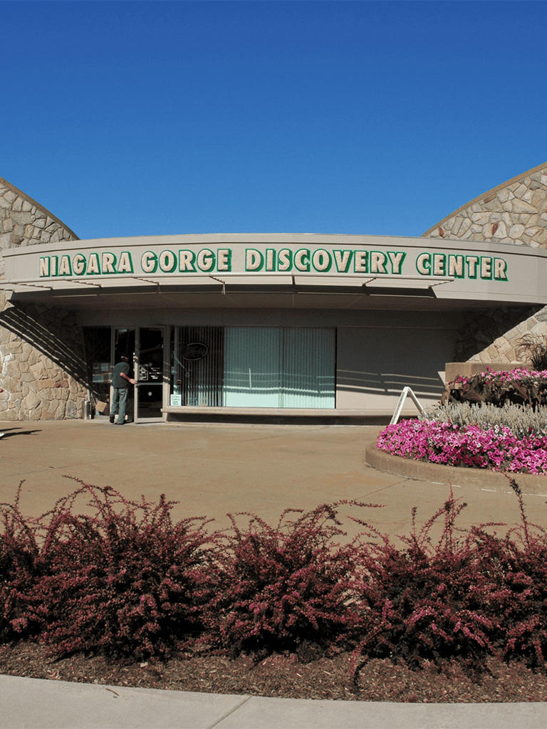 Niagara Gorge Discovery Center entrance with scenic landscaping and clear blue sky.