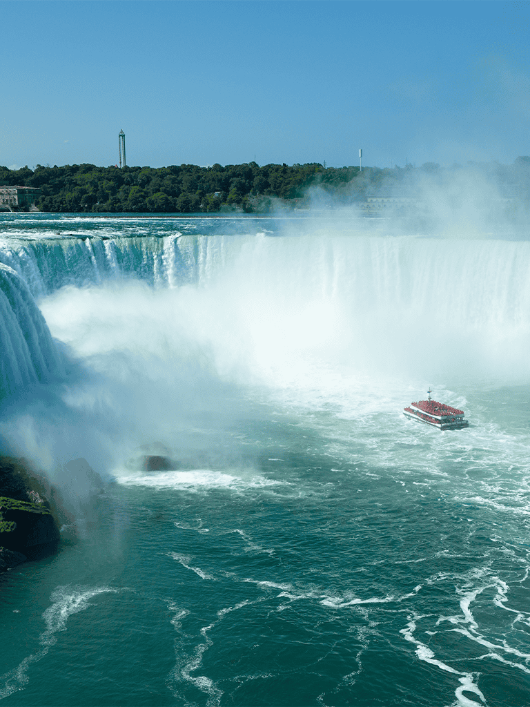 Stunning view of Niagara Falls with a sightseeing boat in the water.