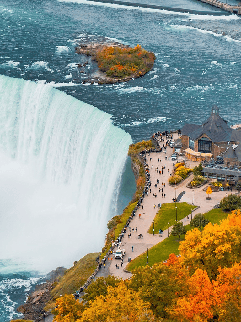 Colorful autumn scenery at Niagara Falls with visitors enjoying the view and park attractions.