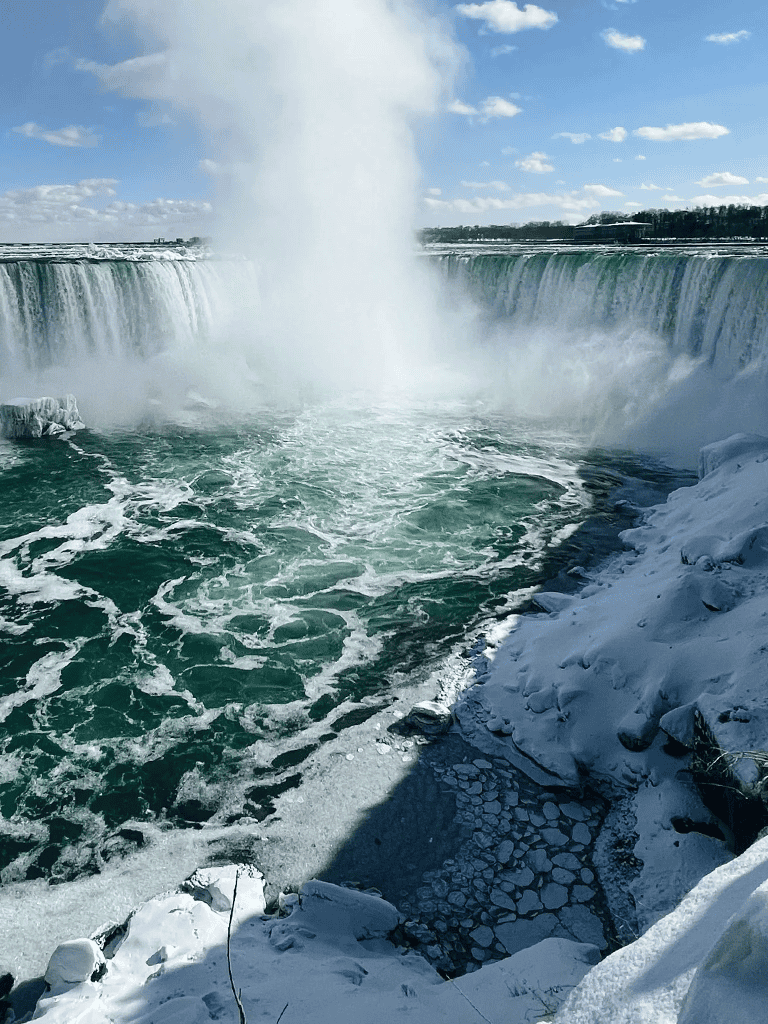 Powerful winter waterfall at Niagara Falls in winter with ice and snow.