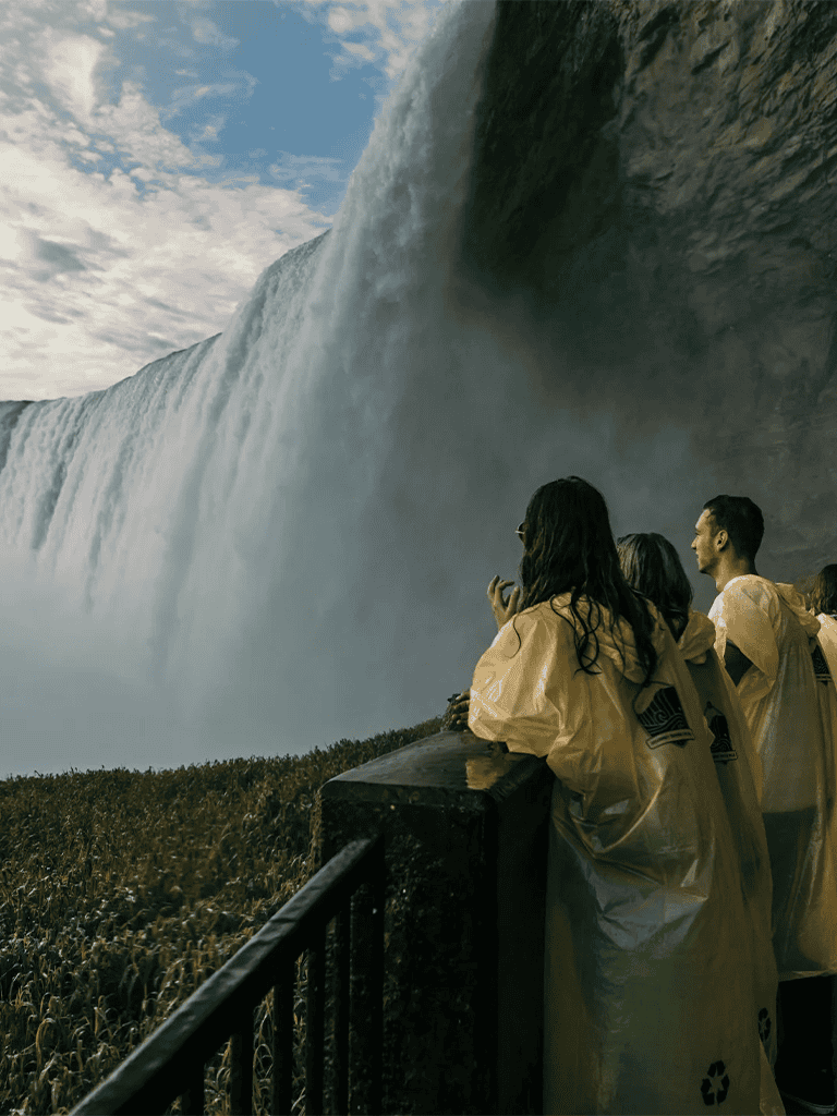 Spectacular waterfall view with tourists observing at scenic overlook for travel and nature photography.