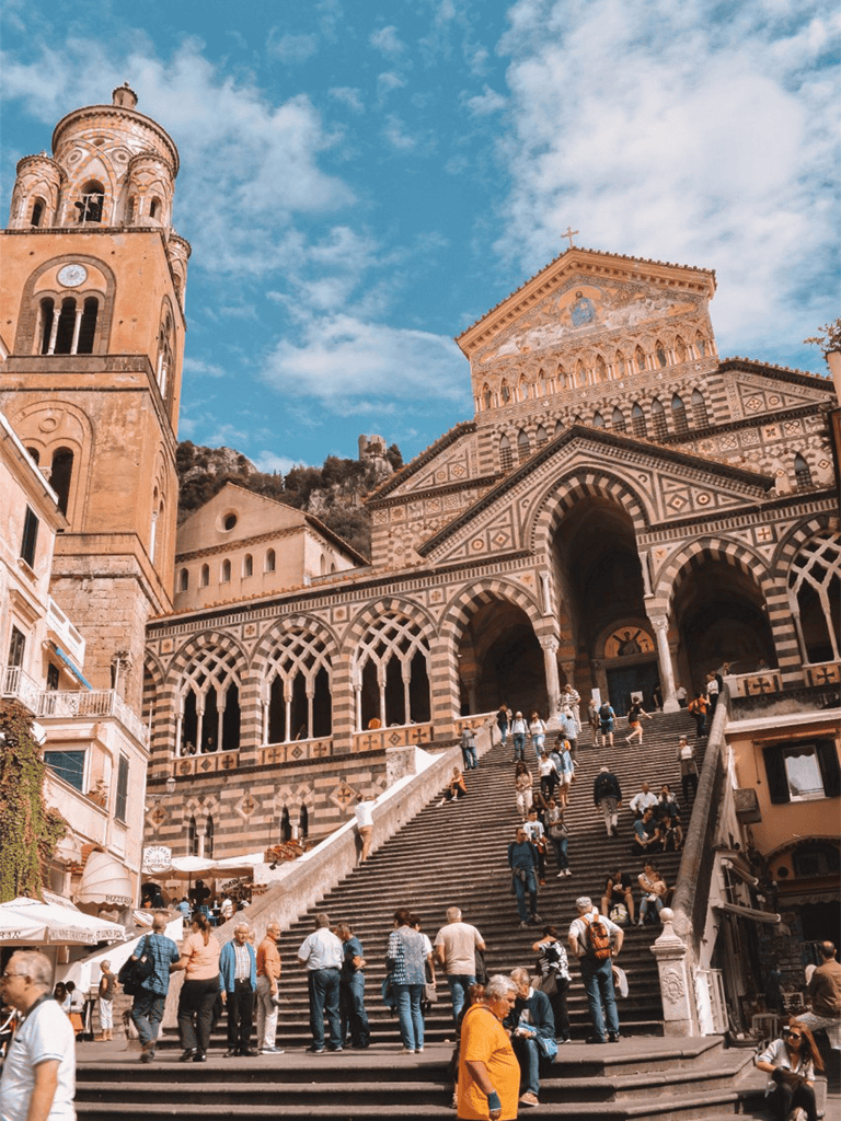 Colorful historical church in Amalfi Coast, Italy under blue sky.
