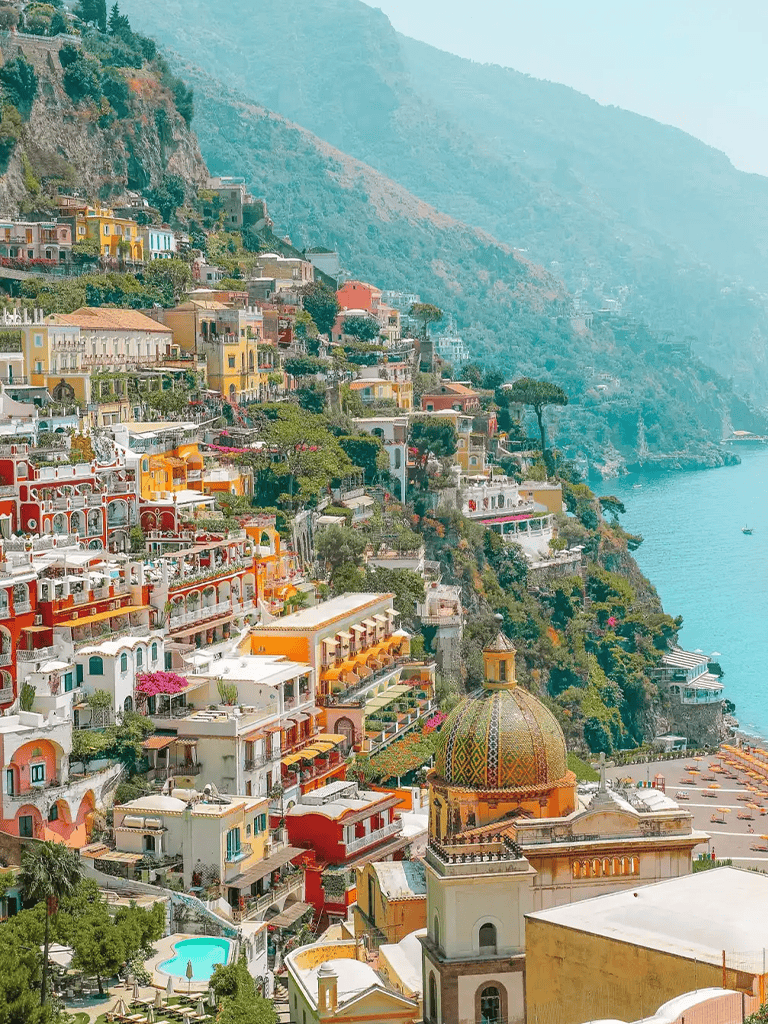 Colorful cliffside seaside town with vibrant buildings and scenic coastal views.