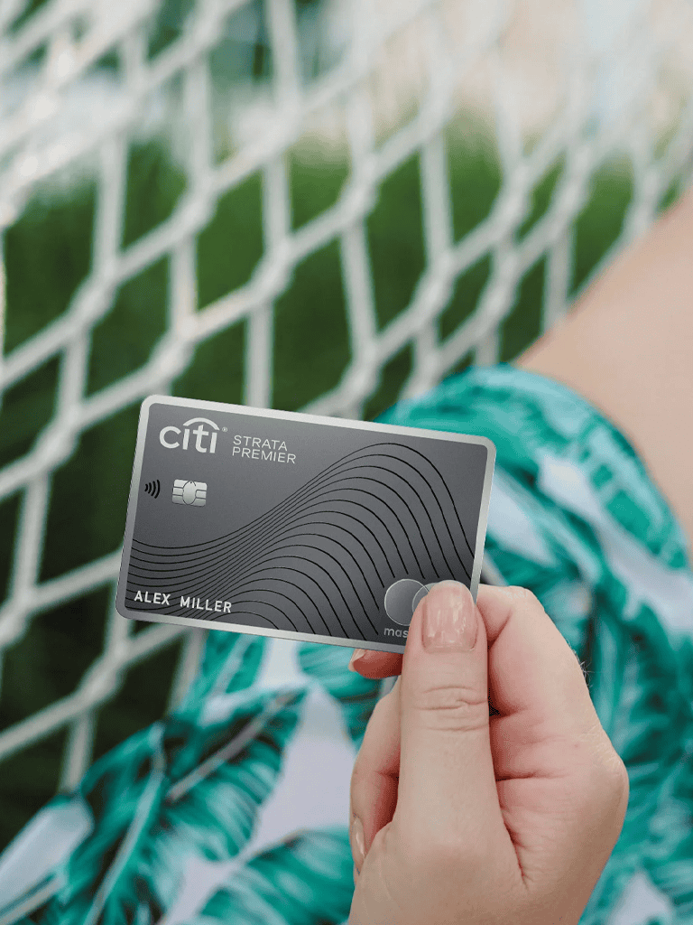 Citi credit card held by person with a green bracelet, on a sports field or court, for online payments.