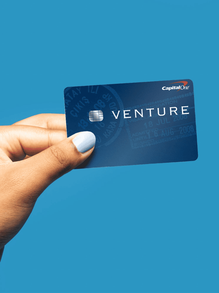 Venture credit card by Capital One on a blue background.