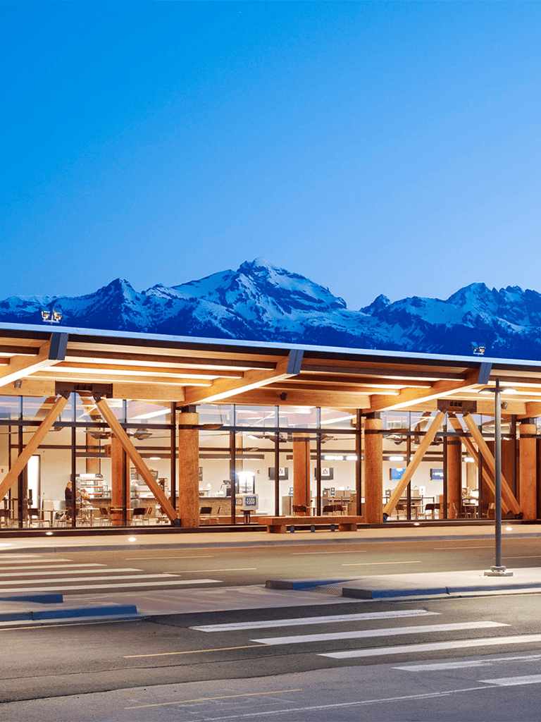 Modern airport terminal with mountain backdrop and scenic views.