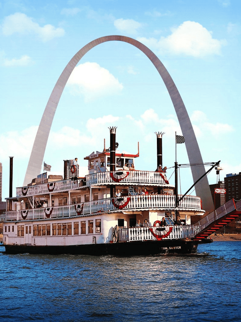 Historic Mississippi riverboat with Gateway Arch in St. Louis, Missouri, highlighting scenic river cruise in the USA.