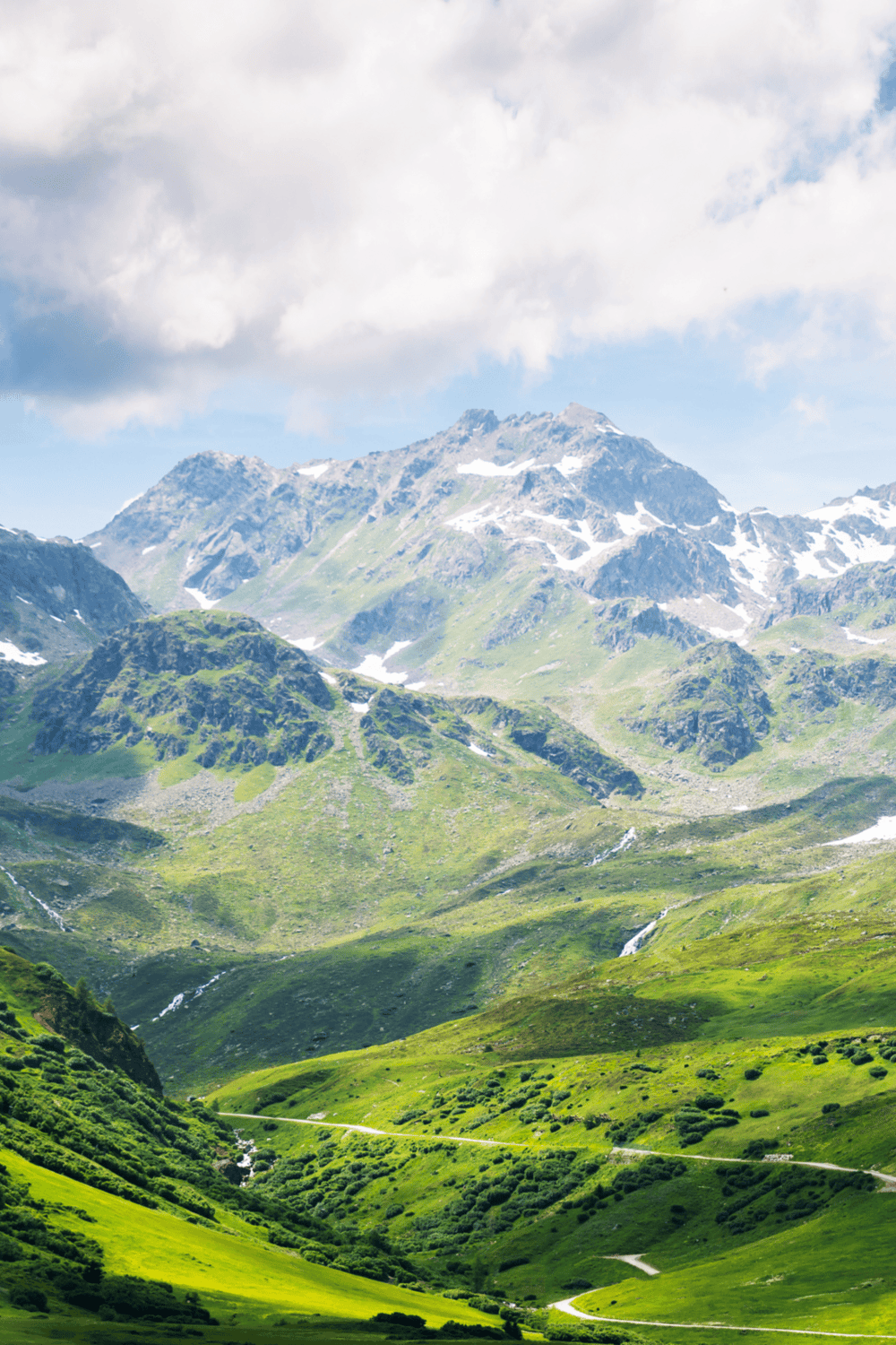 Beautiful scenic mountain landscape with lush green hills and snow-capped peaks.