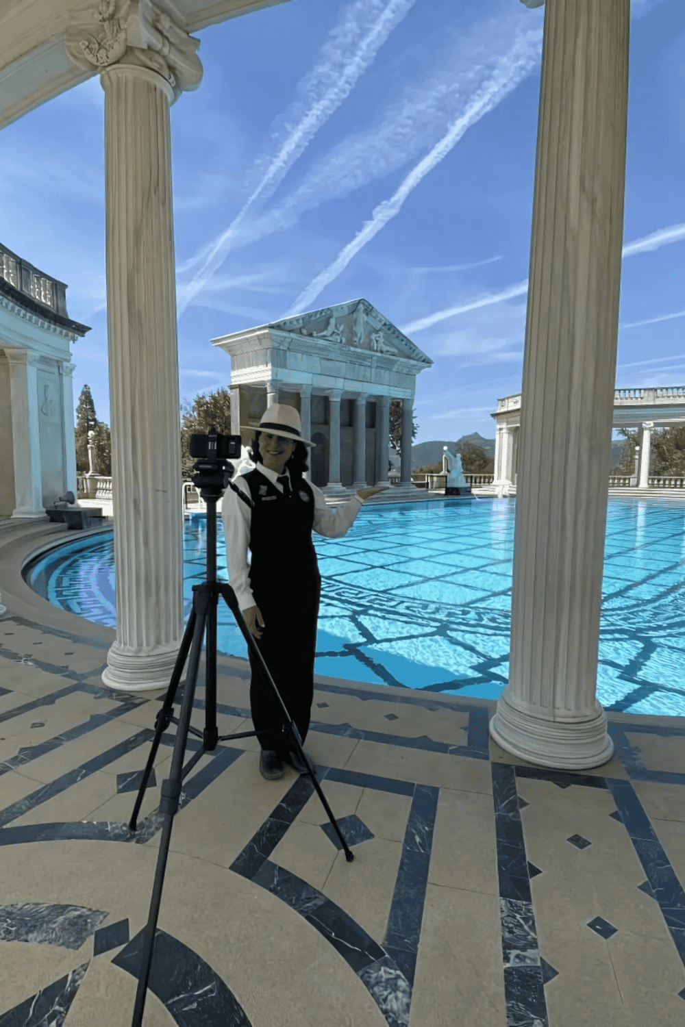 Beautiful Greek-inspired architectural pool area with classic columns and clear blue water.