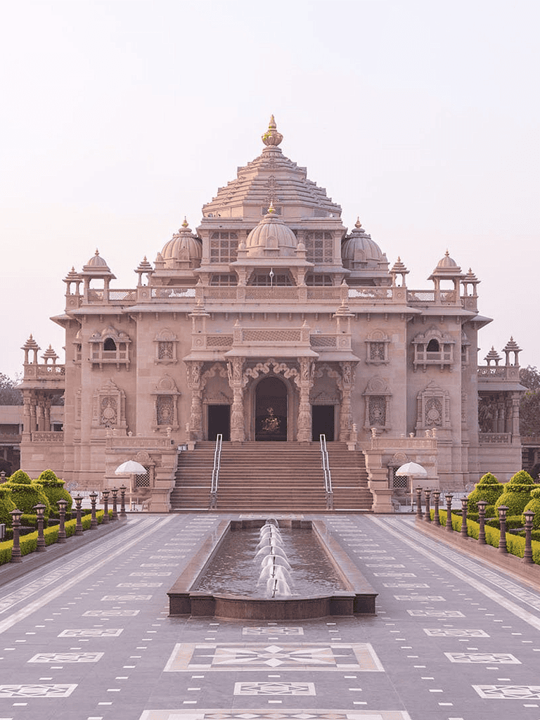 Majestic Hindu temple with intricate architecture and water fountain in the front.