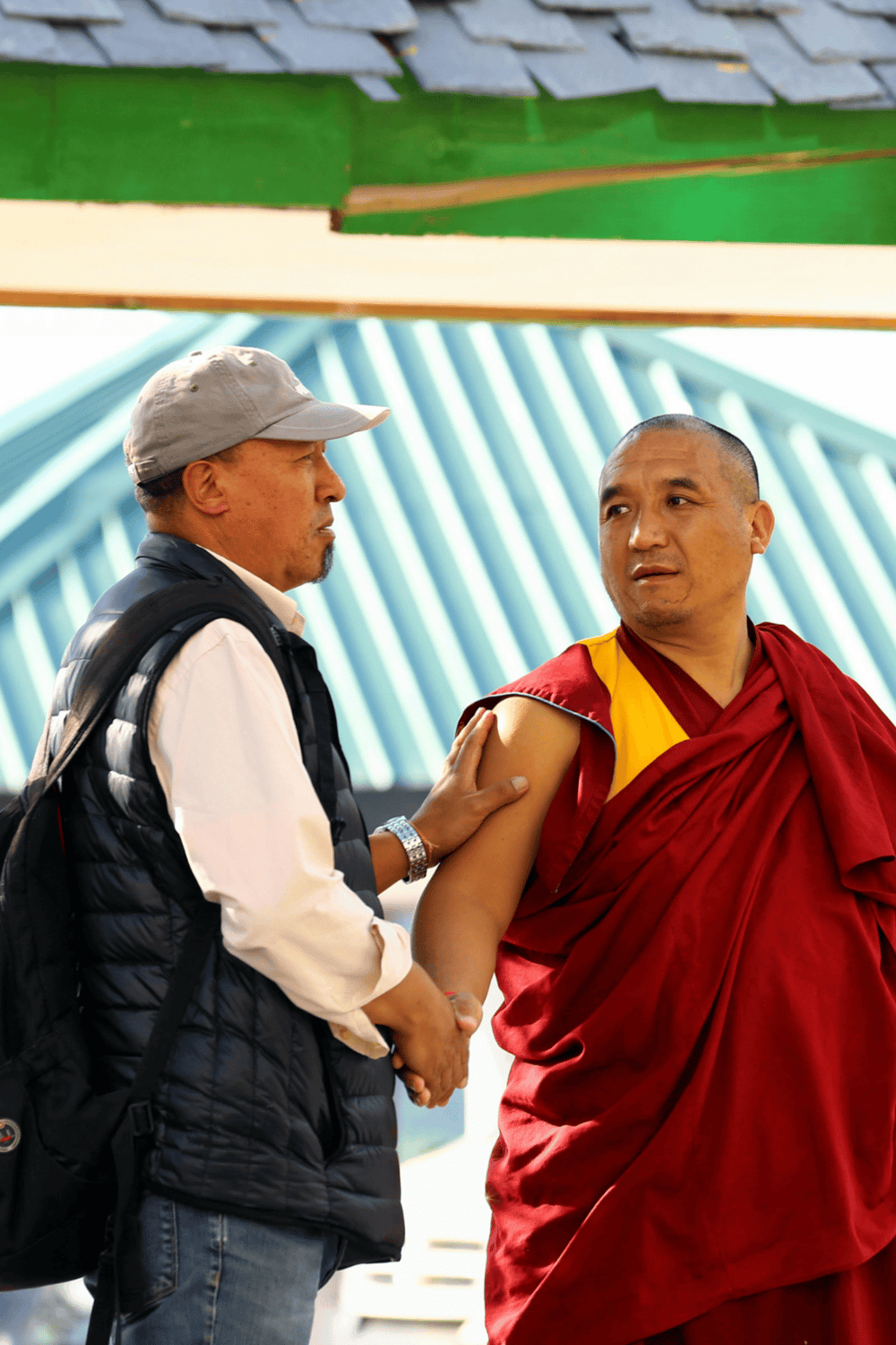 Compassionate healthcare and guidance by a volunteer assisting a Buddhist monk receiving vaccination.