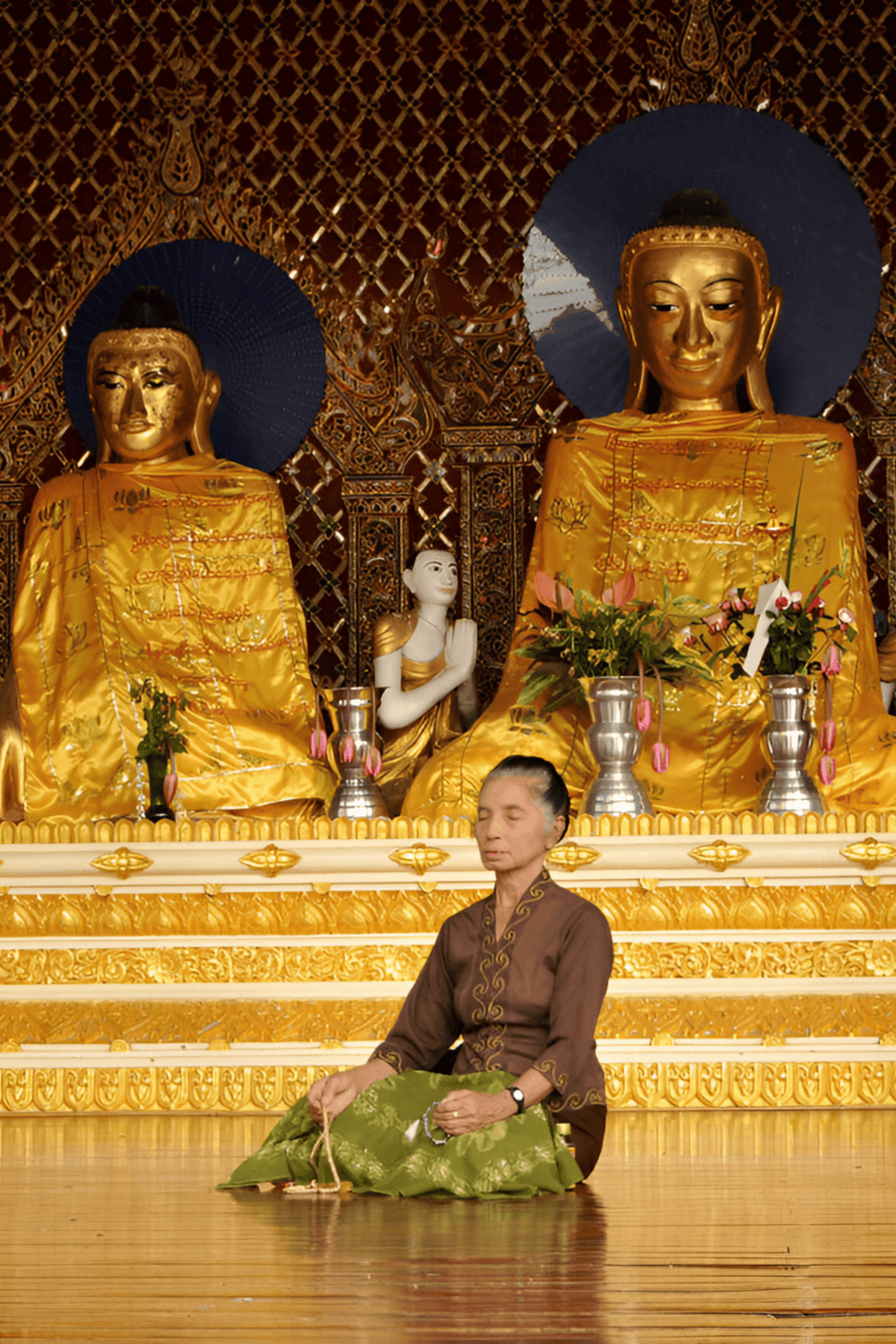 1. Buddha statues in golden robes at a spiritual meditation altar.