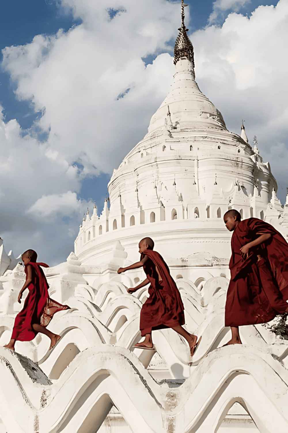 Majestic white pagoda with young monks crossing the ornate steps, showcasing Asian temple architecture.
