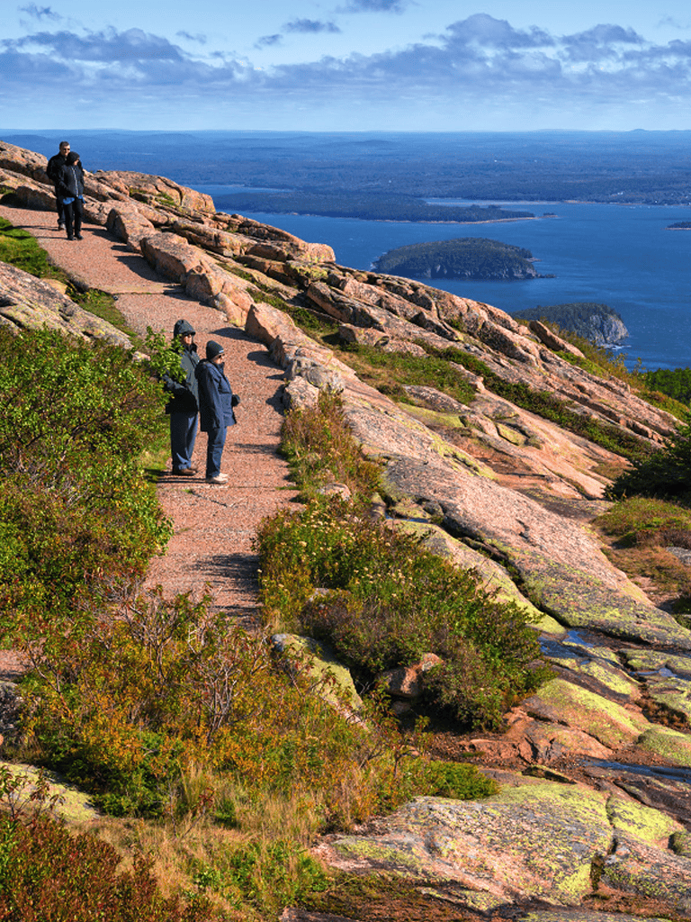Scenic mountain hiking trail overlooking a vast lake and islands, popular for outdoor adventures and nature exploration.