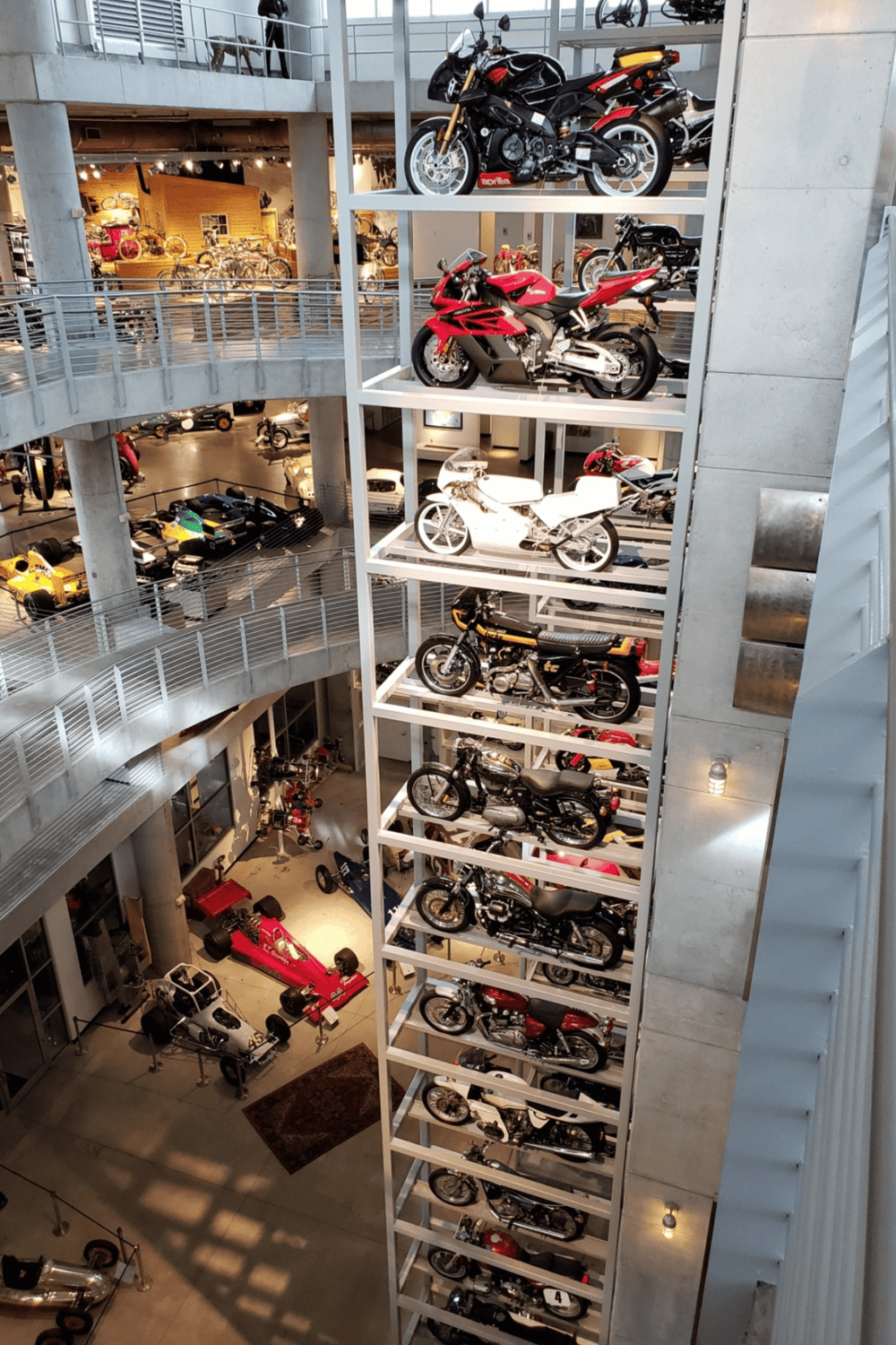 Motorcycle display at automotive museum, showcasing a collection of vintage and modern bikes.