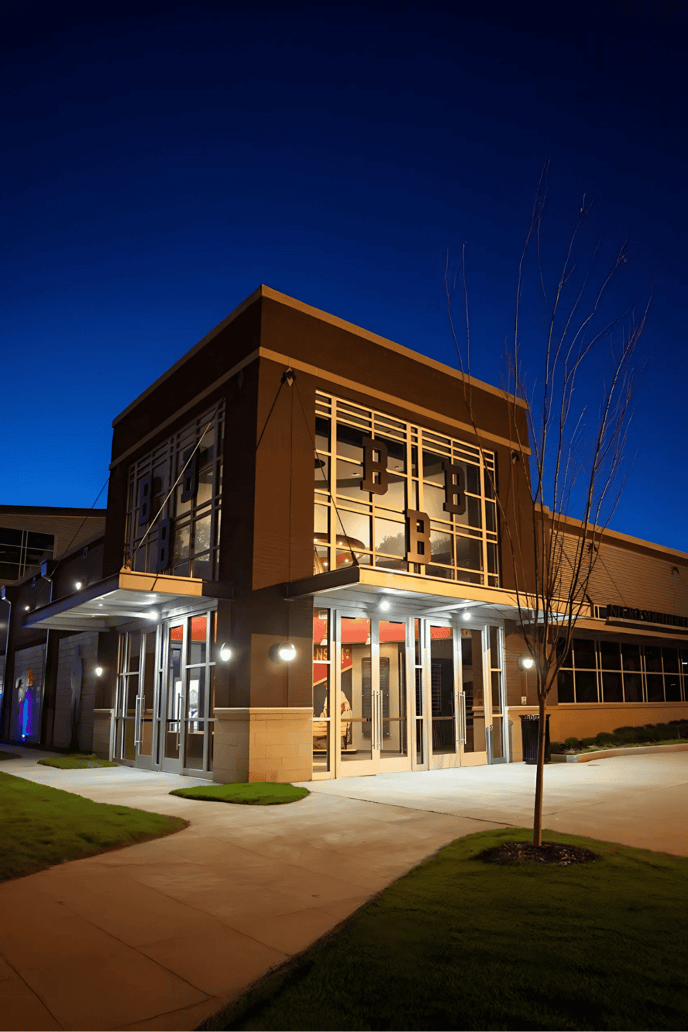 Modern commercial building illuminated at night, showcasing QuestForDirections' location and professional services.