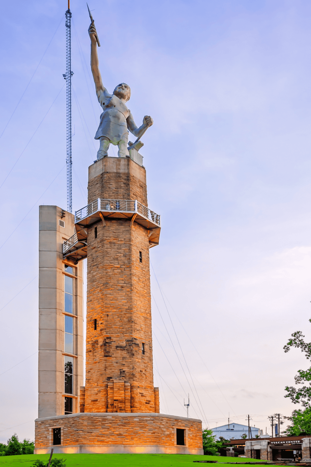 Statue of a boy at the top of a tall brick tower, symbolizing exploration and guidance.