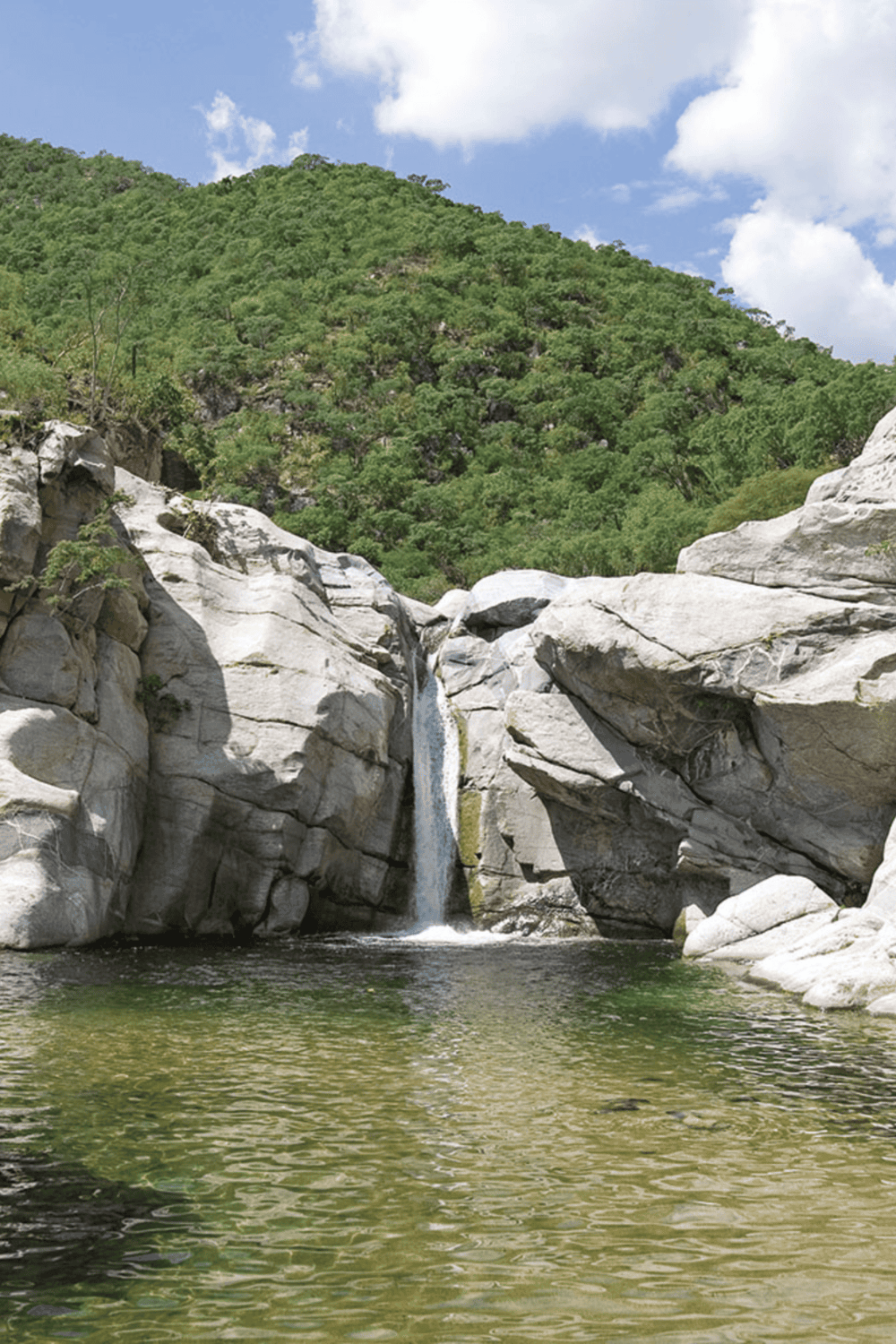Waterfall in lush mountain landscape, natural scenic outdoor adventure spot.