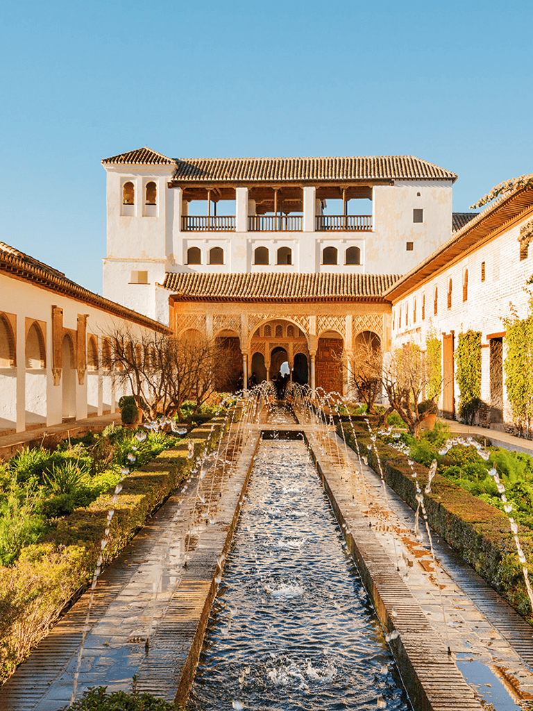 Stone Palace courtyard with fountain and lush garden, Spanish-style architecture, outdoor atrium, Villa del Palmar hotel.