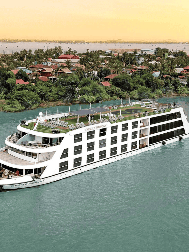 Luxurious cruise ship on water with lush tropical island background, offering scenic travel experiences.