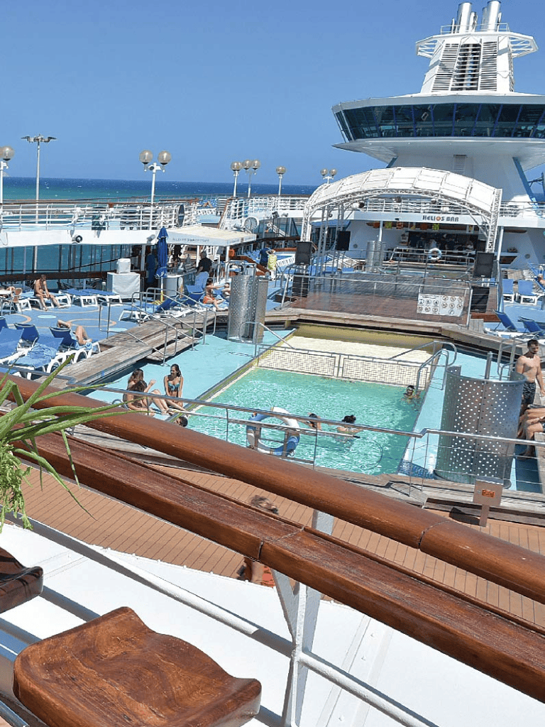 Relaxing cruise ship pool deck with ocean view and lounging guests at QuestForDirections.