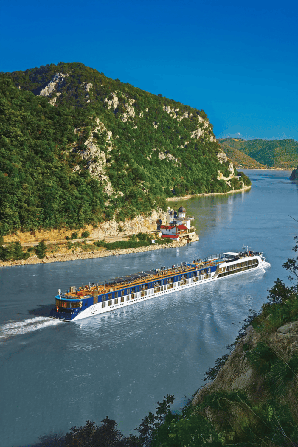 Serene river cruise passing through lush green mountains and picturesque landscapes.