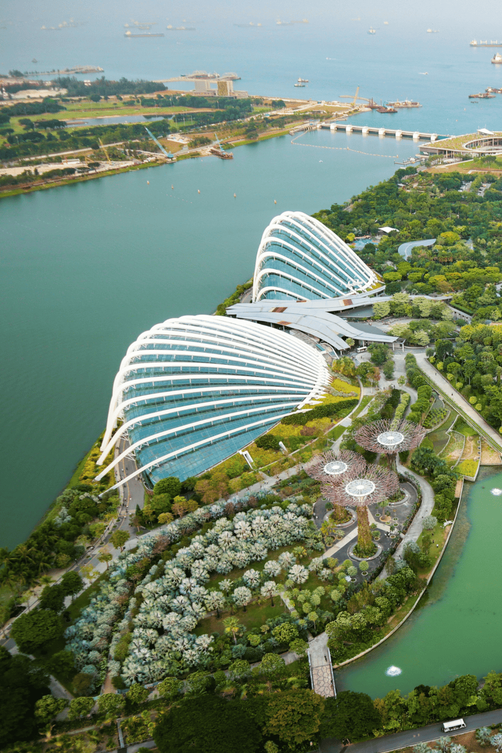 Modern architectural structures with lush surrounding gardens in Singapore featuring the iconic Gardens by the Bay.