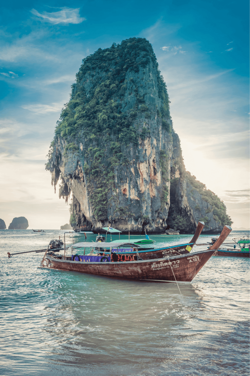 Vibrant boat scene at iconic limestone island in Phuket, Thailand, tropical travel destination.
