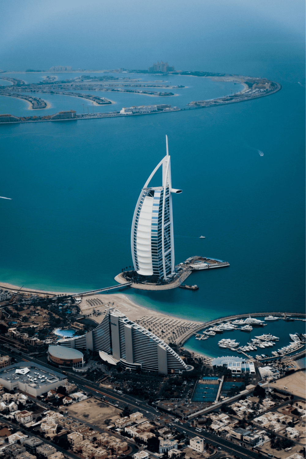 Luxurious Dubai hotel Burj Al Arab with yacht marina and coastline.