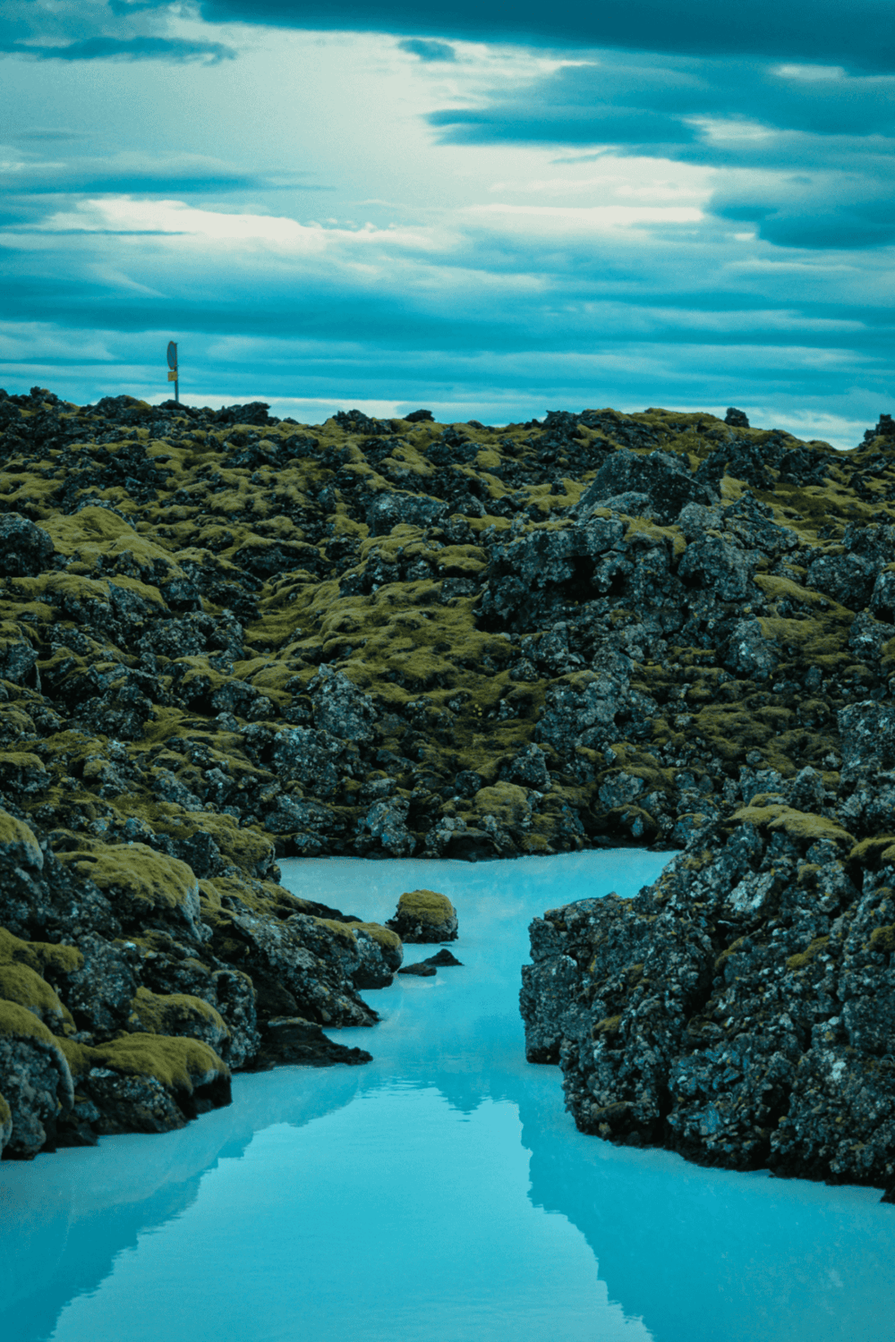 Vast volcanic landscape with moss-covered rocks and a tranquil river in Iceland.