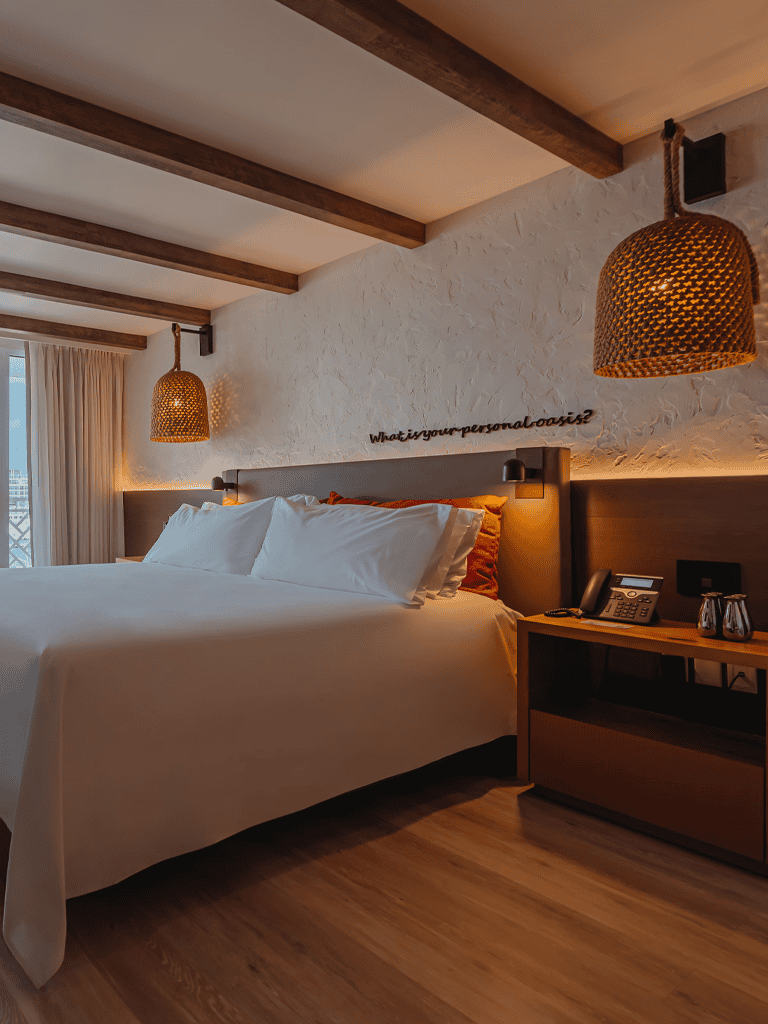 Cozy hotel bedroom with modern decor, warm lighting, and comfortable bedding for relaxation.