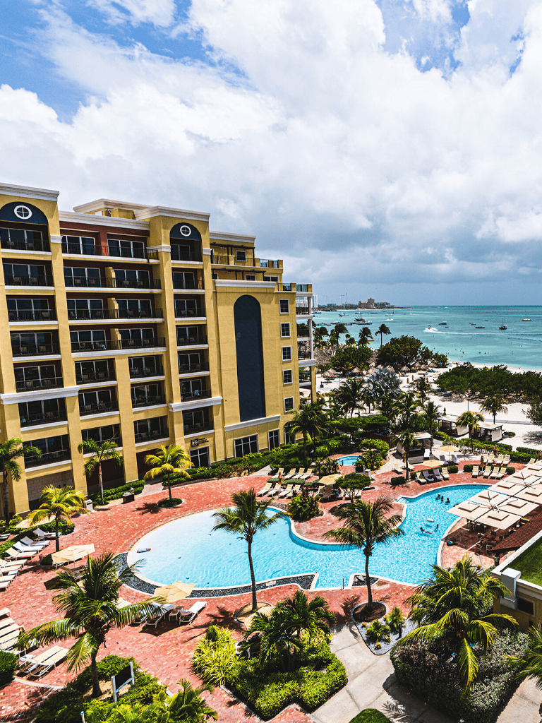 Luxury beachfront hotel with pool, ocean views, and tropical landscaping. Perfect for a relaxing beach vacation.