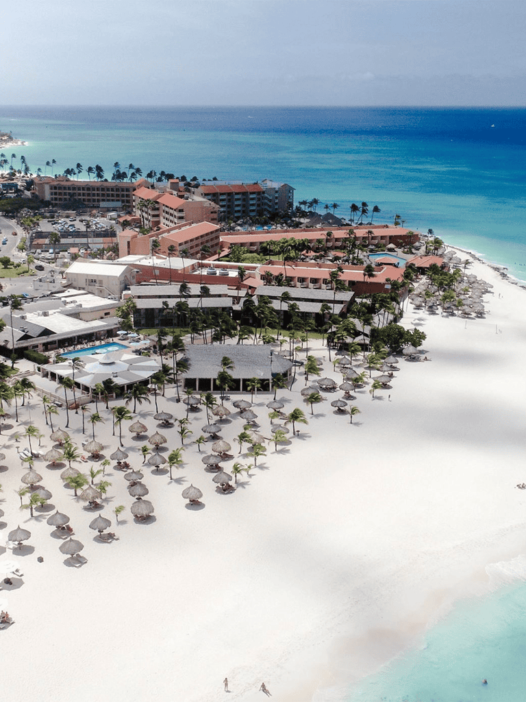 Luxurious beachfront resort with white sand beaches and turquoise water, perfect for tropical vacation.