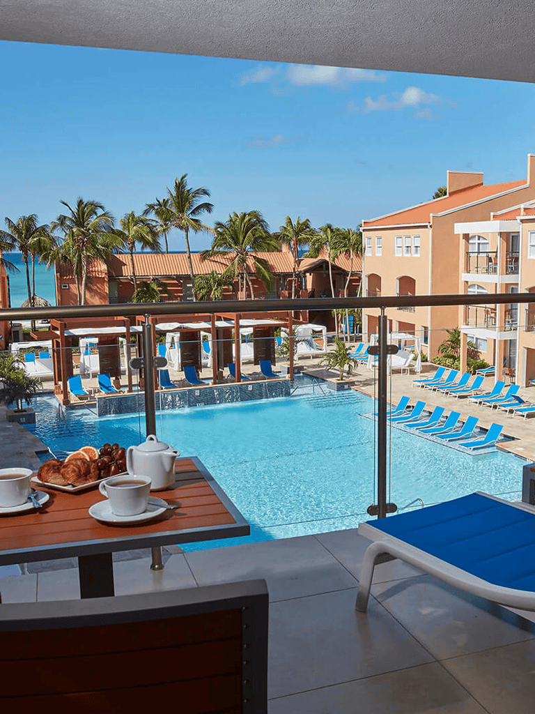 Relaxing poolside view at QuestForDirections hotel with ocean scenery in the background.