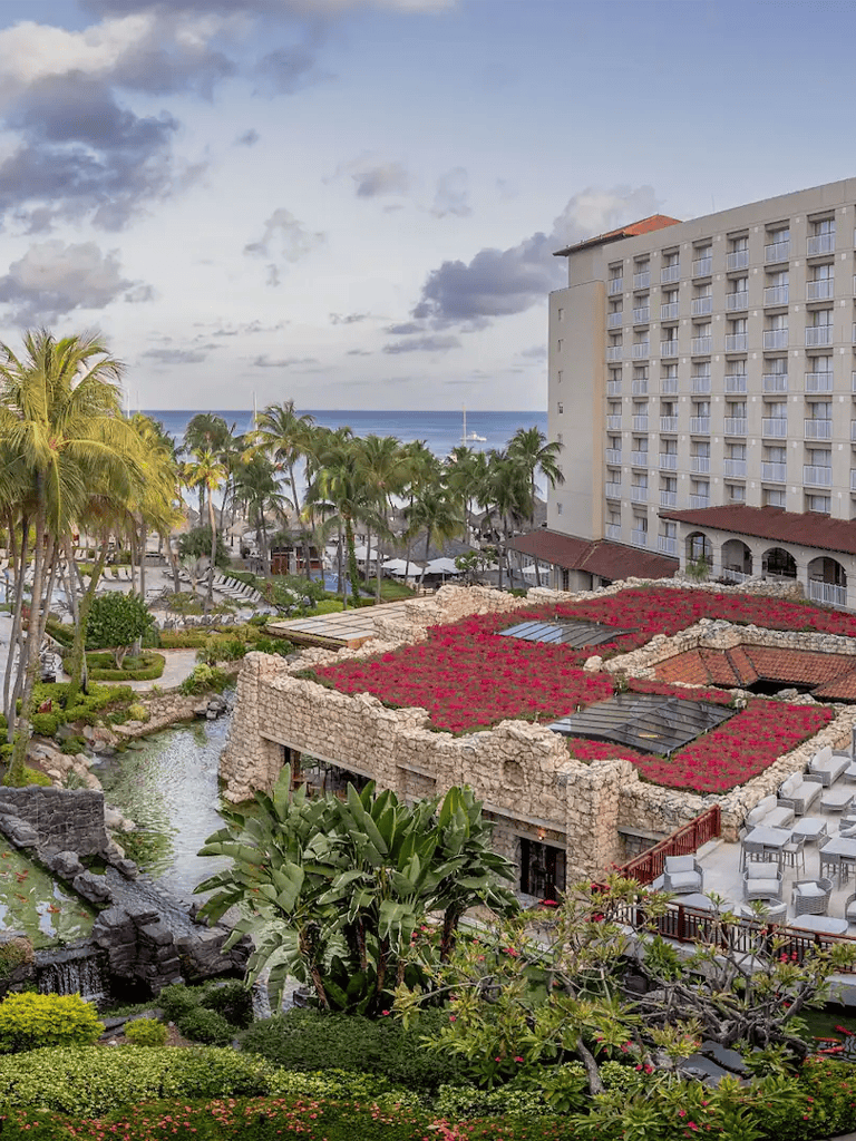 Lush tropical resort with ocean view, palm trees, and garden outdoor seating at QuestForDirections.